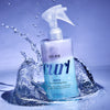 Curl Wow spray bottle with water splash on a blue background
