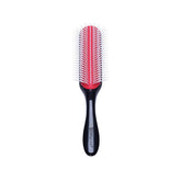A classic Denman hairbrush positioned vertically against a plain white background.