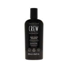 A black bottle of American Crew Daily Silver Shampoo with white and silver text detailing the product name and description.