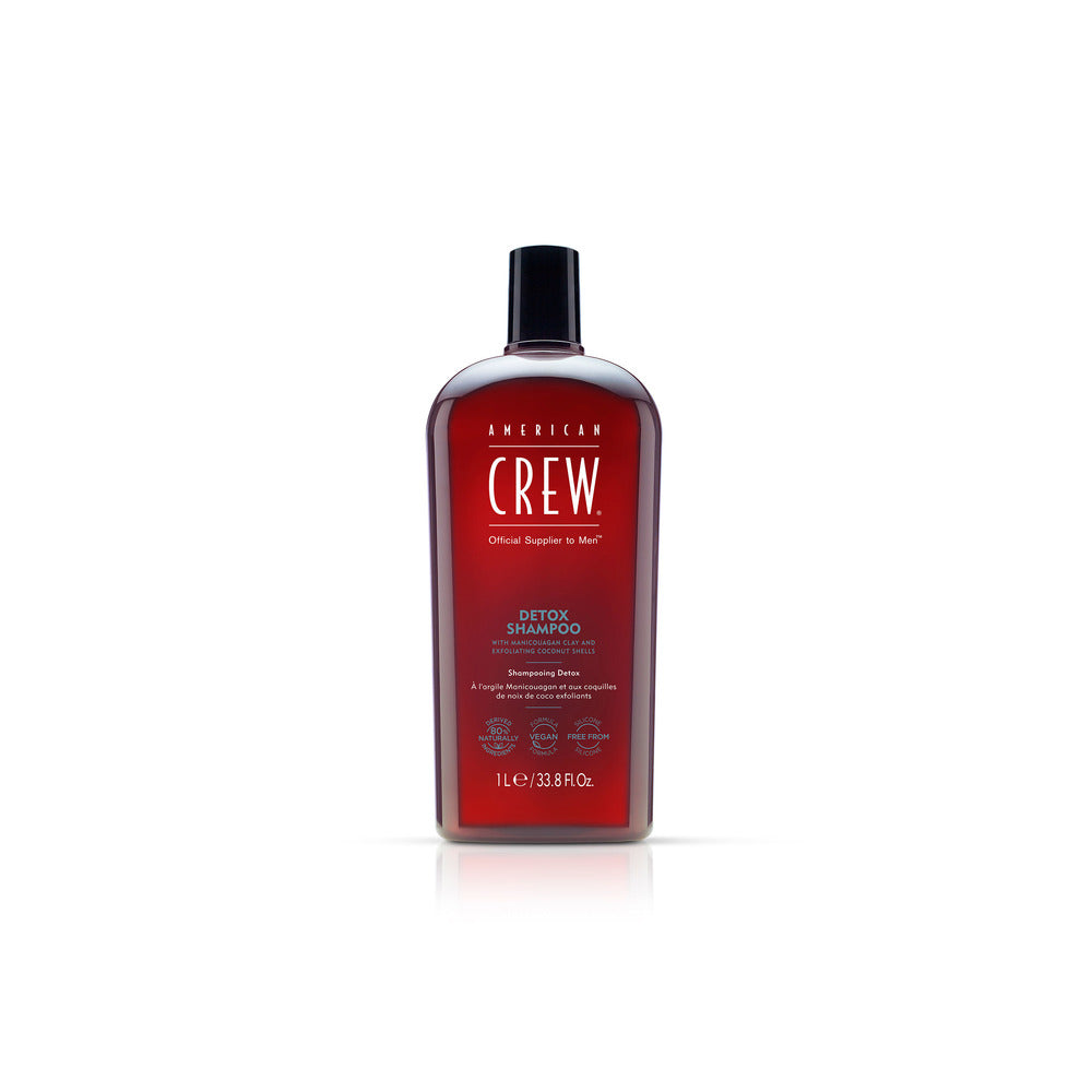 Bottle of American Crew Detox Shampoo with a dark liquid visible through the transparent bottle, labeled for men's haircare.