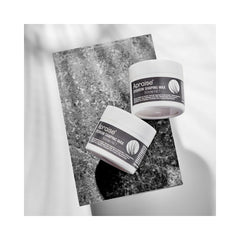 Two pots of the shaping wax on a granite rectangle on a white background.  
