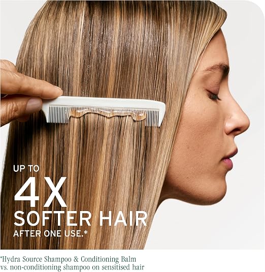 A close-up side profile of a woman with long, straight, light brown hair being combaged by a hand holding a white comb. Large text reads 'UP TO 4X SOFTER HAIR AFTER ONE USE.