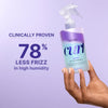 Hand holding a bottle of 'curl' product with text about frizz reduction on a purple background