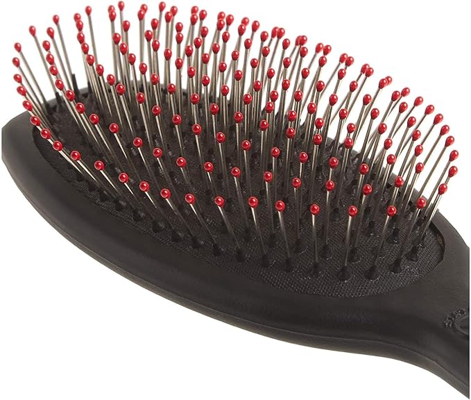 A close-up of a black paddle hairbrush with metal bristles tipped in red, shown against a plain white background.