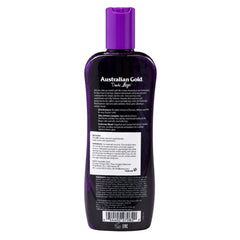 The back of a dark purple bottle of Australian Gold Hair Regrowth shampoo, featuring white text and a white warning label, on a solid white background.
