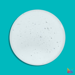 A top-down view of a clear, translucent circular gel or liquid droplet with tiny air bubbles, set against a solid turquoise background.