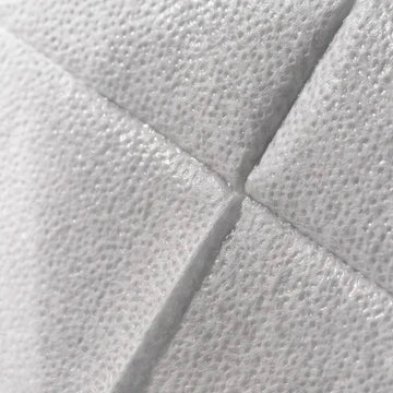 Close-up of a white textured material with a quilted or padded geometric pattern and stitched panel lines.