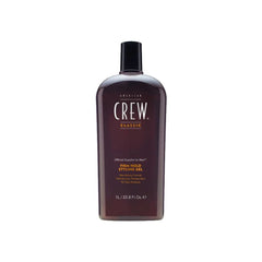 A bottle of American Crew Firm Hold Styling Gel in brown color with a black cap. The label indicates the product is a hair styling gel with a firm hold and enhanced shine, 1000ml size.